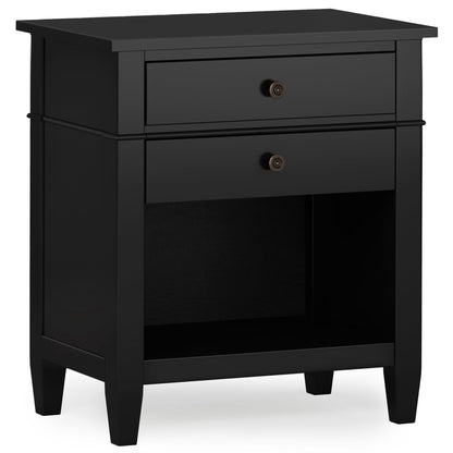 The Carlton Handcrafted Bedside Table features a black wooden finish, one top drawer with two round knobs, an open lower shelf, and stands on four short legs.