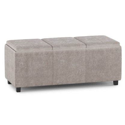Avalon - Upholstered Storage Ottoman in light gray, featuring three cushioned sections and short black legs, shown on a white background.