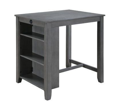 The Graham 3 Piece Small Space Counter Height Dining Table set features a gray wooden table with three side shelves and two chairs, a simple rectangular tabletop, sturdy legs, and a built-in power outlet on the side.