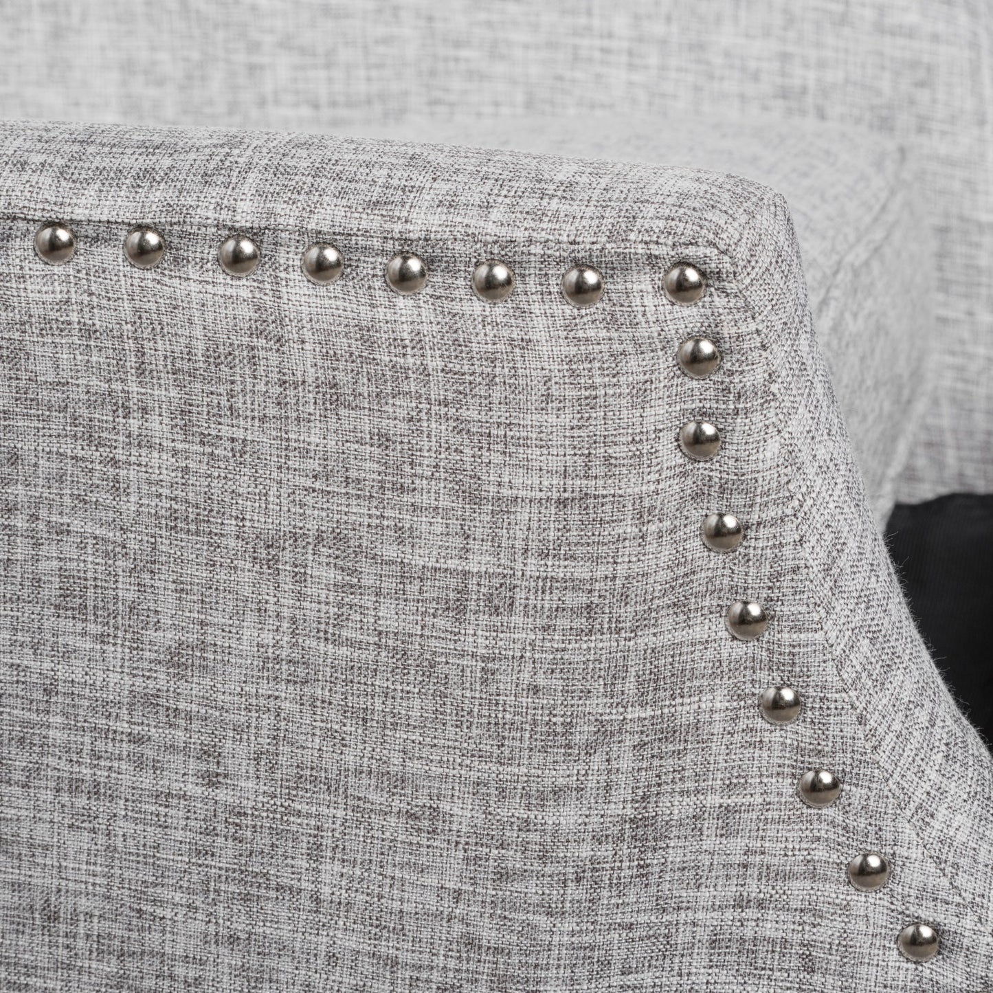 Close-up of the Westeros Wing Back Fabric Upholstered Recliner in light gray, showcasing its textured fabric and a row of silver nailhead trim along the curved armrest.