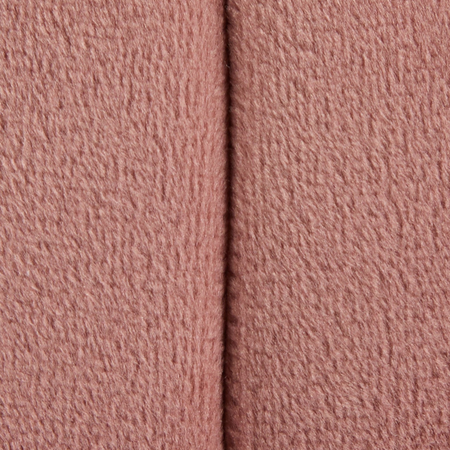 Close-up of the Braided - Versatile Round Ottoman shows its soft, textured pink fabric with a vertical seam running down the center.