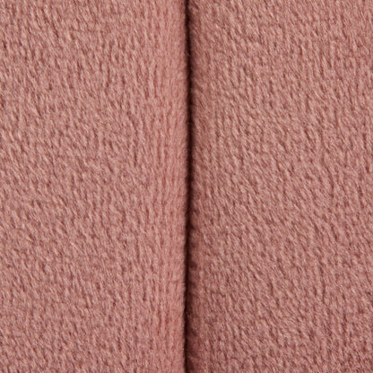 Close-up of the Braided - Versatile Round Ottoman shows its soft, textured pink fabric with a vertical seam running down the center.