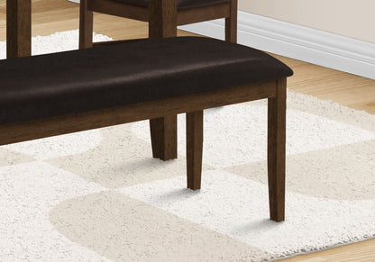 A close-up of a Rectangular Upholstered Bench in a transitional style sits on a cream and white patterned rug, with part of a matching chair and hardwood floor in the background.