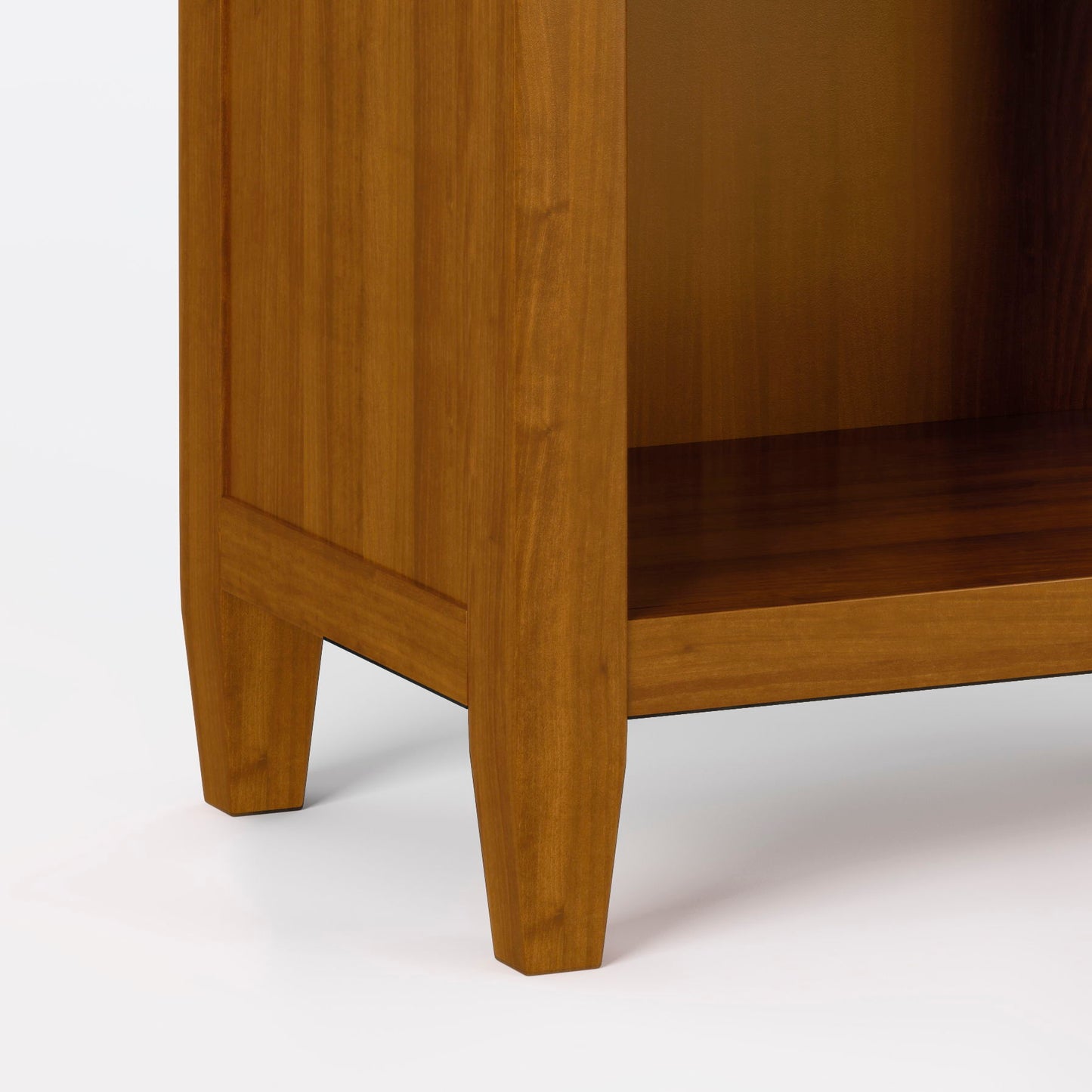 Close-up of the Carlton - Bedside Table, Handcrafted, highlighting its warm brown finish, sturdy tapered legs, and part of the open shelf in the lower corner.