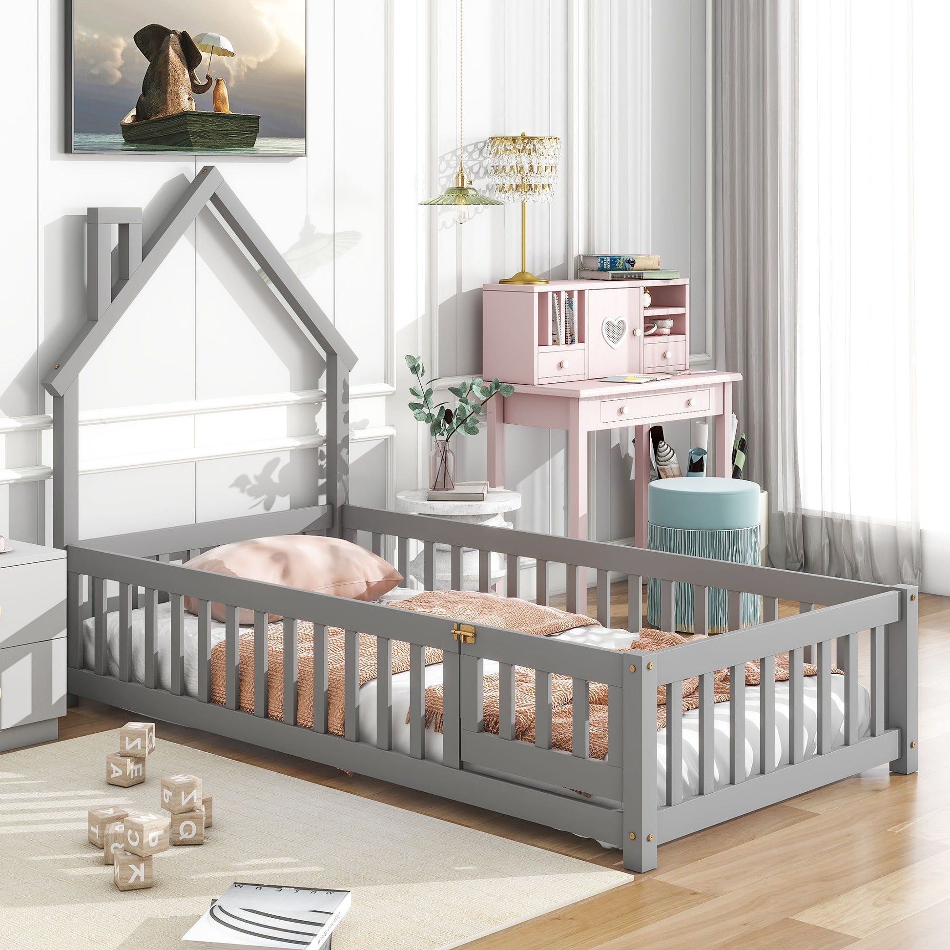 A bright, airy children's bedroom featuring the House-Shaped Headboard Floor Bed With Fence in gray, light brown bedding, a pink desk with heart detail, mint green stool, wooden alphabet blocks, and dog-by-the-sea wall art.