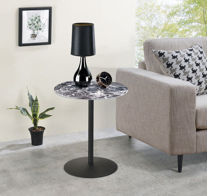 A modern living room features the Circa 17.5" End Table with a marble-textured top, displaying a black lamp and an alarm clock beside a beige sofa with patterned pillows, a potted plant, and wall art in the background.