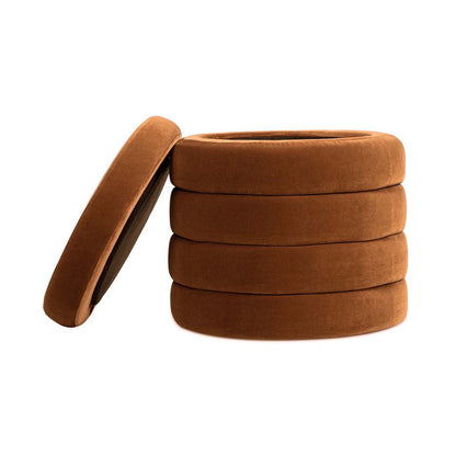The Fuji - Oversized Round Storage Ottoman is a round, brown, stackable piece with a removable lid, featuring soft, velvety fabric and a design that resembles a stack of tires.