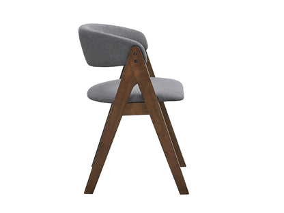 The Keiki Side Chair (Set of 2) features a modern wooden frame with angled legs and gray fabric upholstery on the seat and curved backrest, shown from the side against a white background.