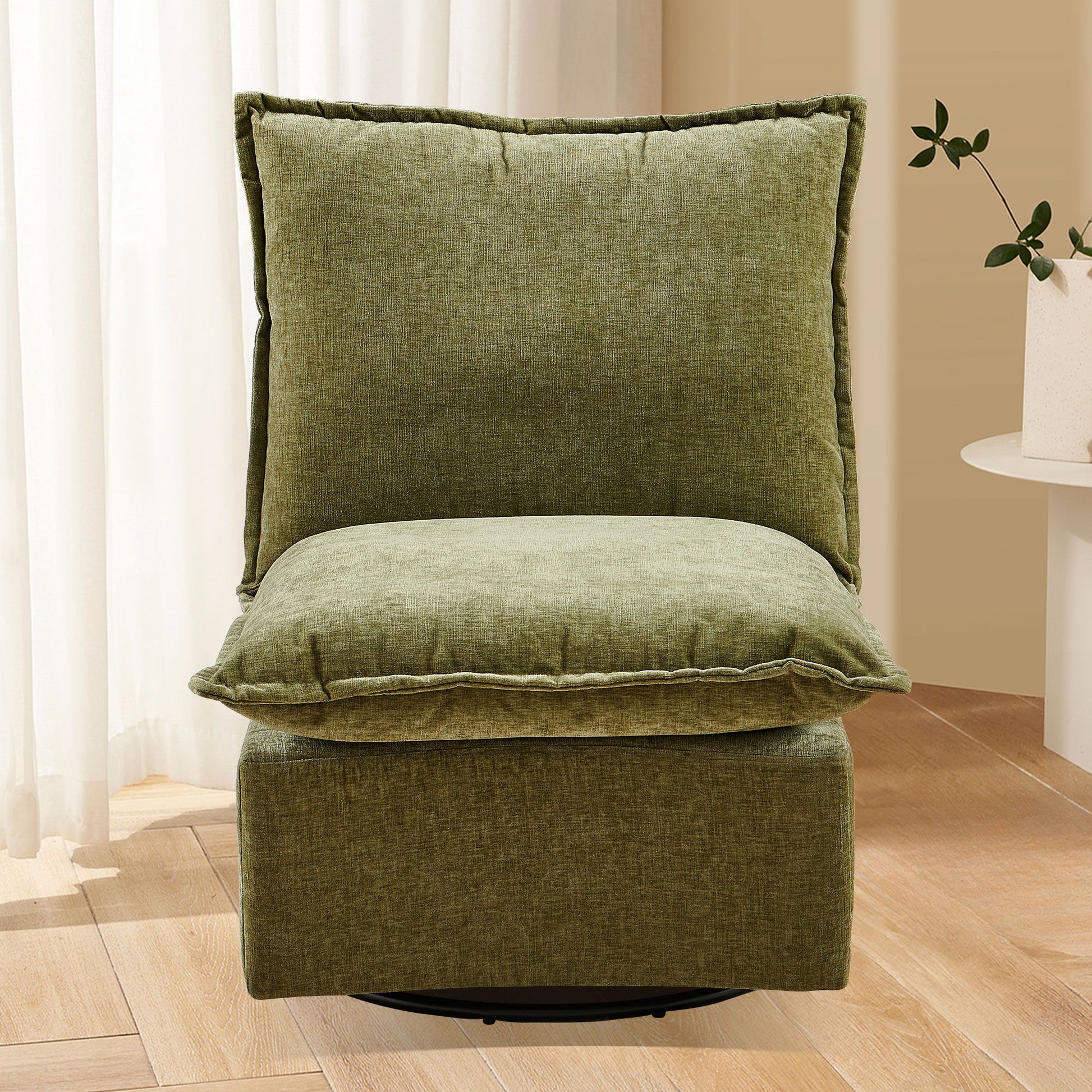The Detachable Chenille Single 360 Swivel Rocking Rocker offers plush comfort in a green armless design, set on a wooden floor with beige walls, white curtains, and a round table with a potted plant in the background.