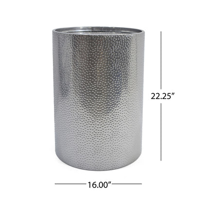 The Modern Round Accent Table features a cylindrical silver metal design with a hammered surface, measuring 22.25 inches high and 16 inches in diameter.