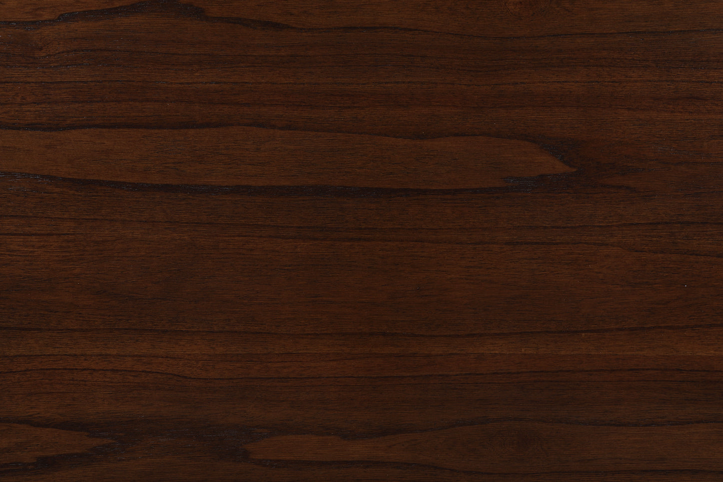 Close-up of the Graham dining table's dark brown wooden surface reveals its grain patterns and natural color variations, offering both texture and modern functionality with USB charging ports and shelves.