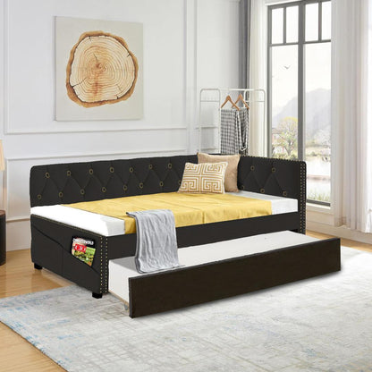 A modern bedroom with the Upholstered Twin Size Daybed Bed Frame in velvet, featuring a pull-out trundle, yellow bedding, gray blanket, and a side pocket for magazines. Large windows provide natural light; a rack in the corner holds clothes.