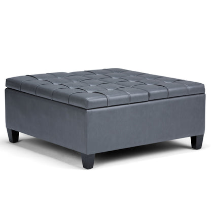The Harrison Upholstered Coffee Table Storage Ottoman is a square, dark gray tufted piece with short black legs and leather or faux leather upholstery, shown on a white background.