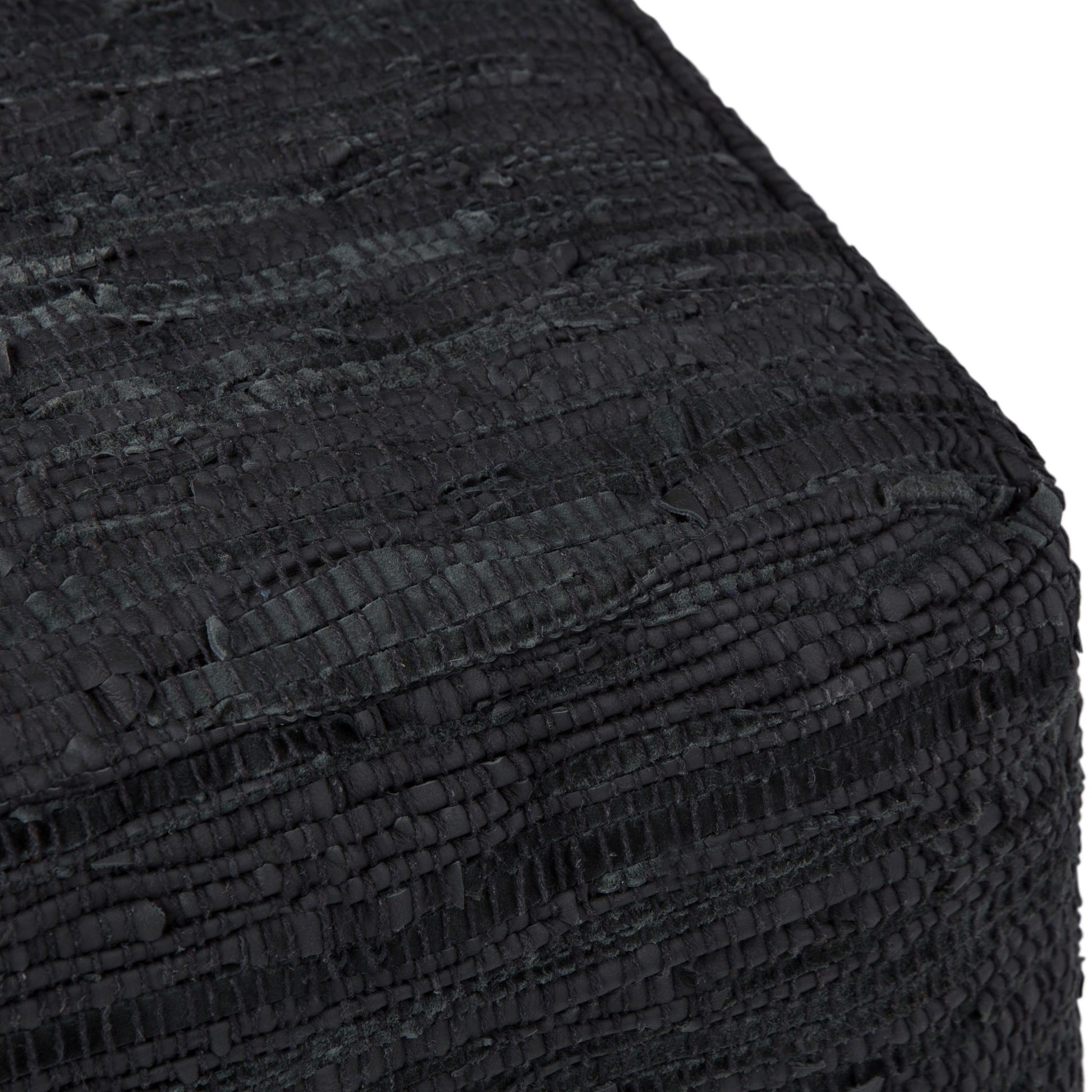 Close-up of the corner of the Fredrik - Handcrafted Square Pouf, highlighting its textured black fabric and woven, ridged pattern.