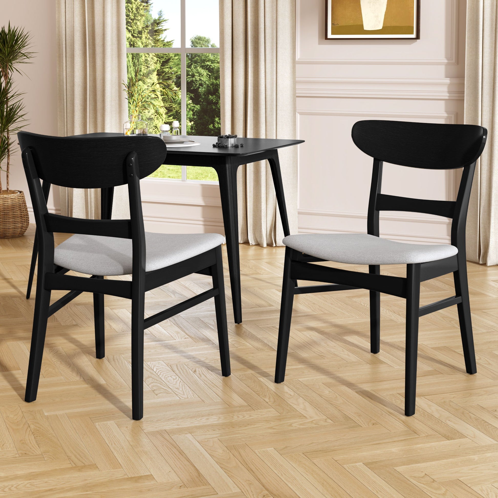 Two Mid Century Dining Chairs with cushioned seats and wood frames (set of 2) are placed by a small black table in a bright room with wood flooring, cream walls, large windows, and beige curtains.