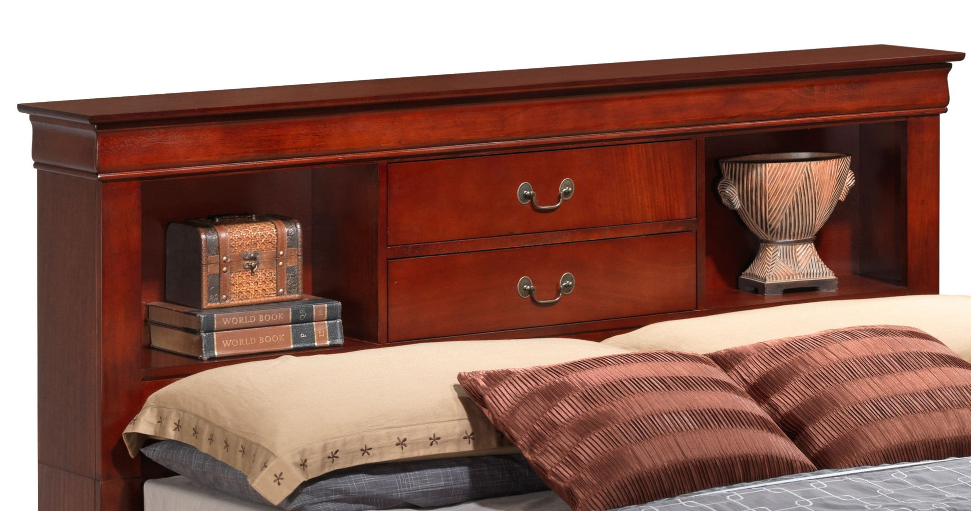 The Louis Phillipe - Bookcase Storage Bed features a wooden headboard with shelves, two central drawers, books, a small chest, and a decorative vase. The bed is styled with beige and brown pillows plus a tan blanket.