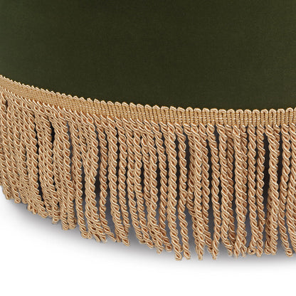 A close-up of the Yolanda Round Upholstered Accent Ottoman, featuring green velvet fabric and a decorative beige fringe trim with loops along the edge.