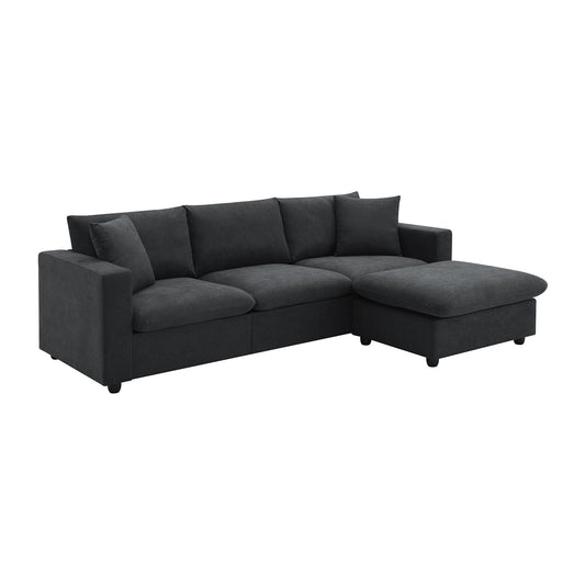 A modern dark gray L-shaped sectional sofa, featuring wide armrests, plush cushions, a right-side chaise lounge, two free pillows, and a convertible ottoman. Ideal for living rooms, apartments, or offices. Shown against a white background.