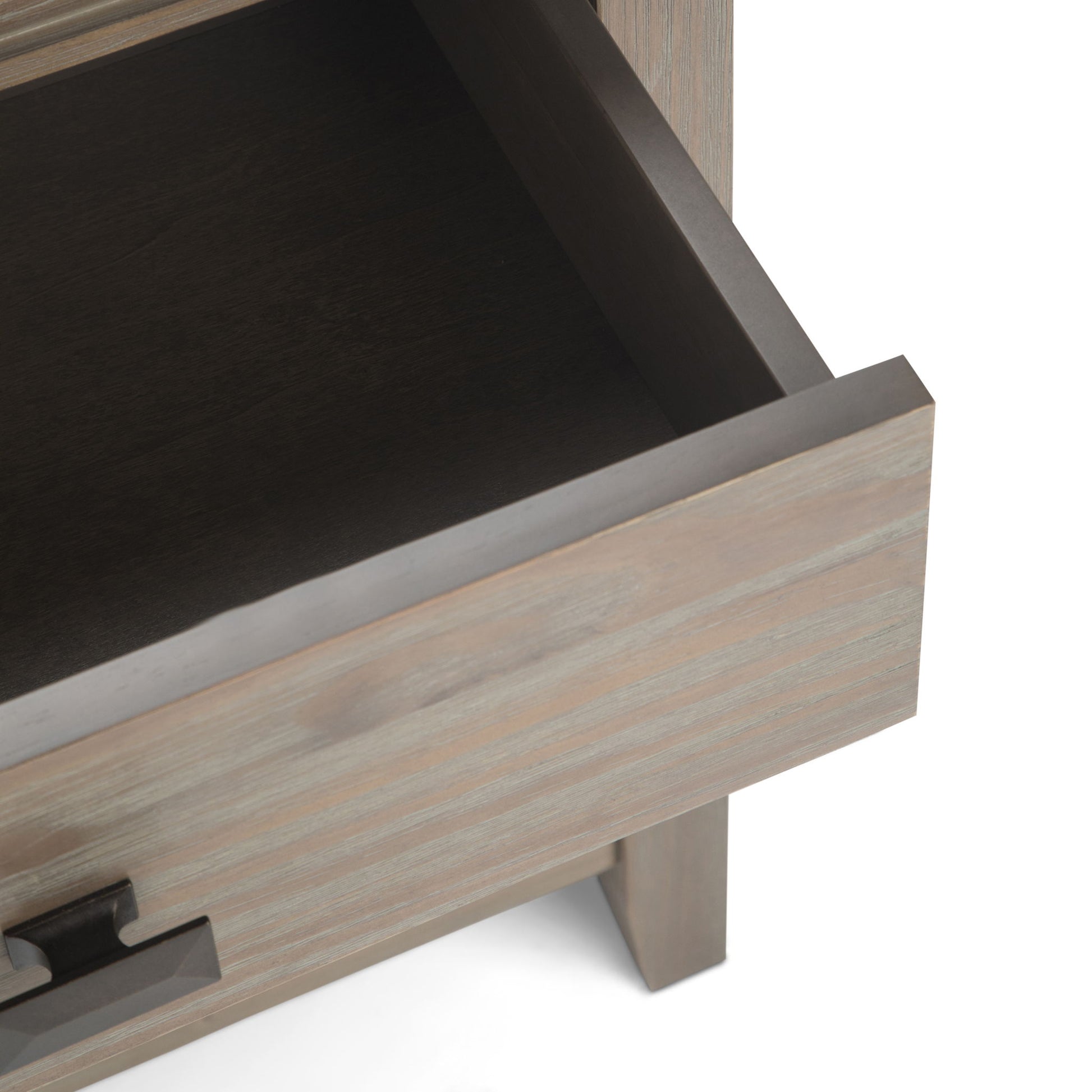 A close-up of the Artisan - Handcrafted Bedside Table shows an open wooden drawer with a metal handle, revealing its empty interior and part of the surrounding cabinet.