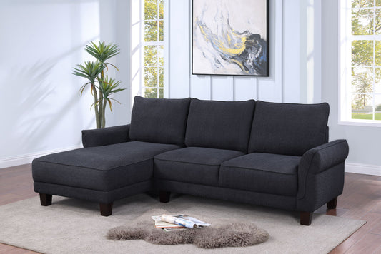 A modern living room featuring the Belle Sherpa Sectional Sofa with Left Facing Chaise in dark gray on a light rug, a fuzzy throw, potted plant, books, large windows, and an abstract painting on the wall.