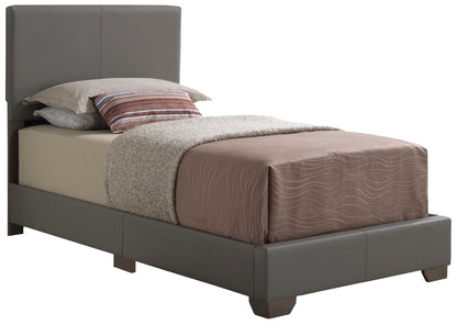 The Elegant Platform Bed For Relaxed Spaces features a gray upholstered frame, beige fitted sheet, light gray textured blanket, and assorted pillows including one with brown and white stripes—a modern choice for any bedroom.