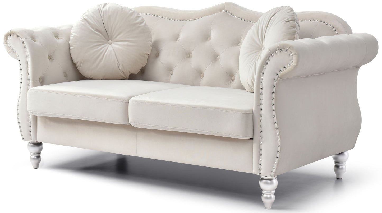 The Stylish Flared Arm Loveseat features a white tufted design with rolled arms, studded trim, two seat cushions, round decorative pillows, and stands on short turned legs.