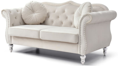 The Stylish Flared Arm Loveseat features a white tufted design with rolled arms, studded trim, two seat cushions, round decorative pillows, and stands on short turned legs.