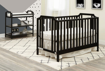 Modern nursery with a black crib, star and polka dot bedding, the Celeste Changing Table with shelves, geometric wall art, and a cream patterned rug on light wood floors.