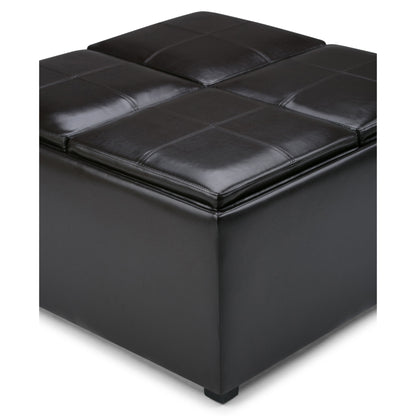 A close-up of the Avalon Square Coffee Table Storage Ottoman in Tanners Brown, featuring black leather, visible stitching, and four cushioned sections. Its simple, modern design makes it a stylish storage solution.