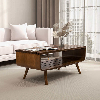 A modern living room featuring a white sofa, the Alice Mid-Century Modern Table with a book and vase of dried flowers, light curtains, and soft natural light streaming through a large window.