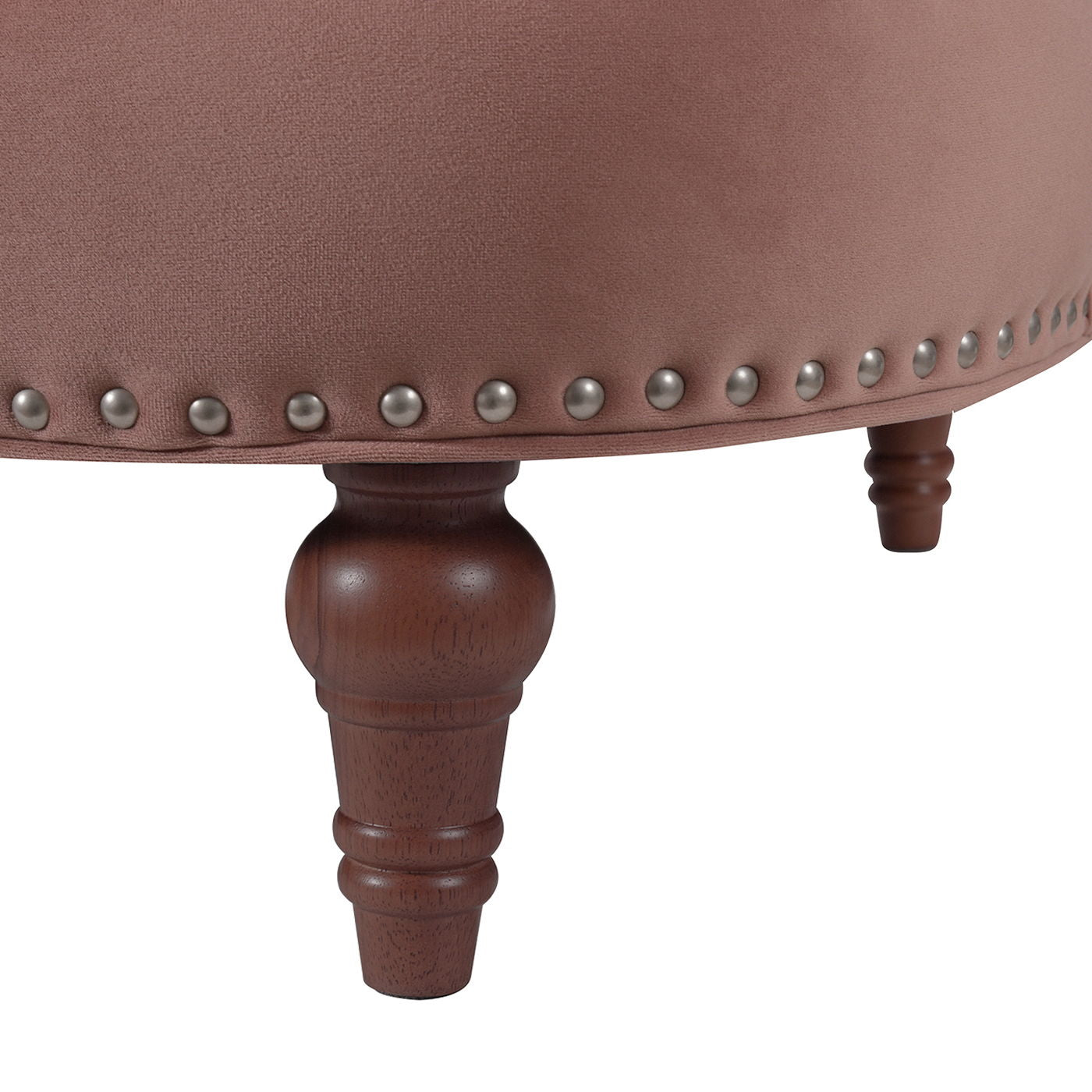 Close-up of the La Rosa - Victorian Chesterfield Tufted Sofa featuring pinkish upholstery, decorative metal studs along the edge, and dark wooden turned legs.