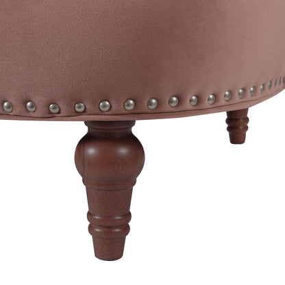 Close-up of the La Rosa - Victorian Chesterfield Tufted Sofa featuring pinkish upholstery, decorative metal studs along the edge, and dark wooden turned legs.
