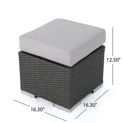 The Santa Rosa Outdoor Lounge Ottoman features a square design with a gray cushion, dark woven base, and silver feet. It measures 16.3" W x 16.3" D x 12.5" H, perfect for outdoor lounging.