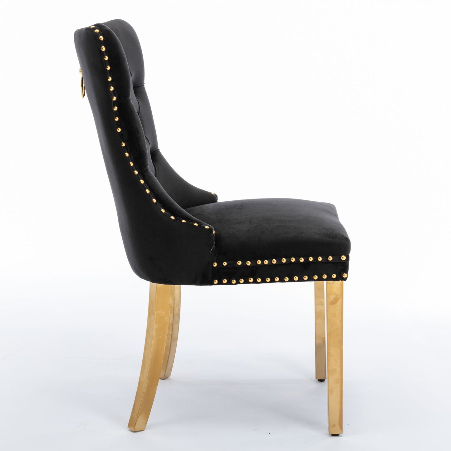 The Nikki Modern Velvet Upholstered Dining Chair set features a high tufted back, nailhead trim, and golden stainless steel legs, shown in profile against a white background. This contemporary chair offers luxurious black upholstery and solid wood construction.