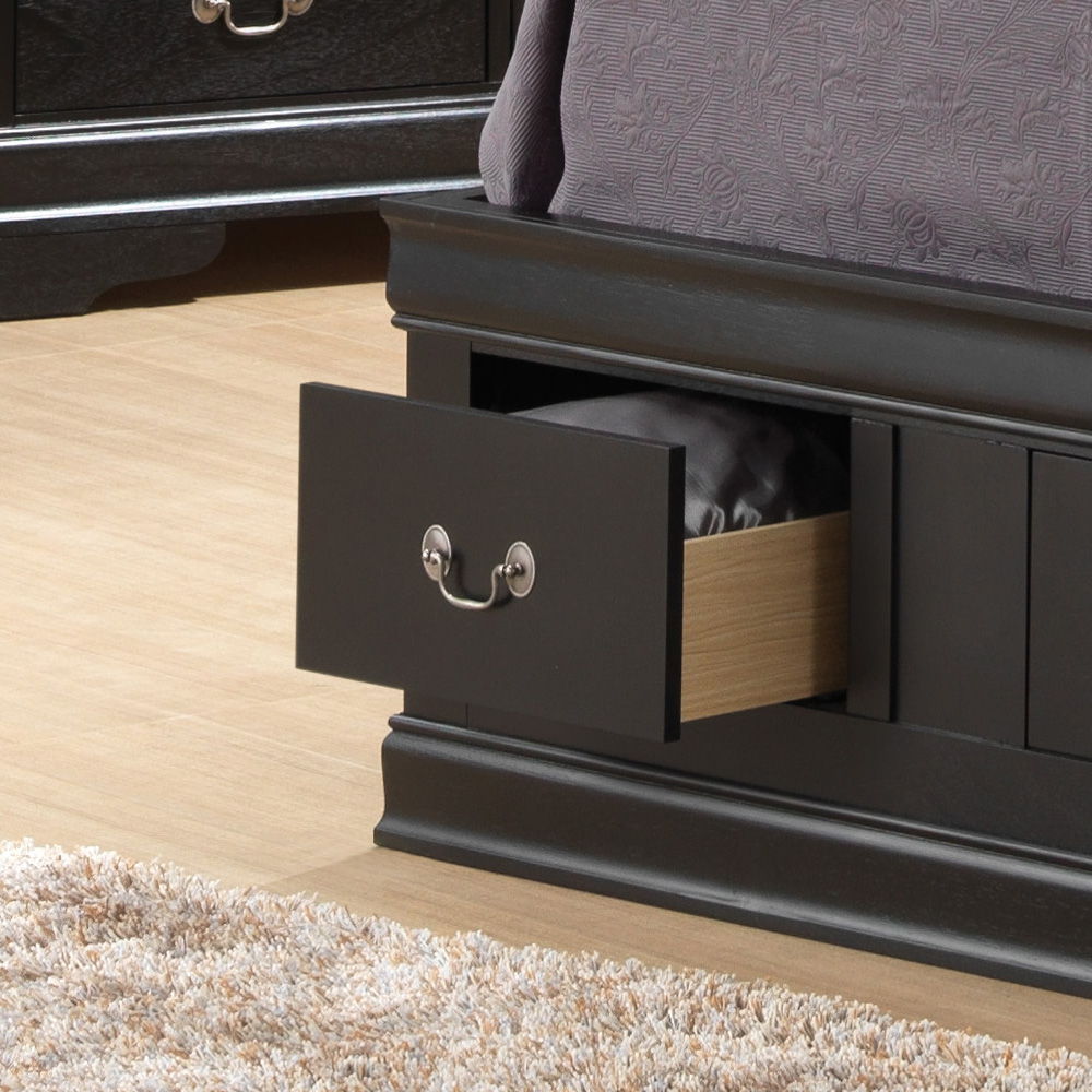 A close-up of the Louis Phillipe - Bookcase Storage Bed in black shows an open base drawer with bedding inside. The drawer features a silver handle, and a beige carpet is visible on the nearby floor.
