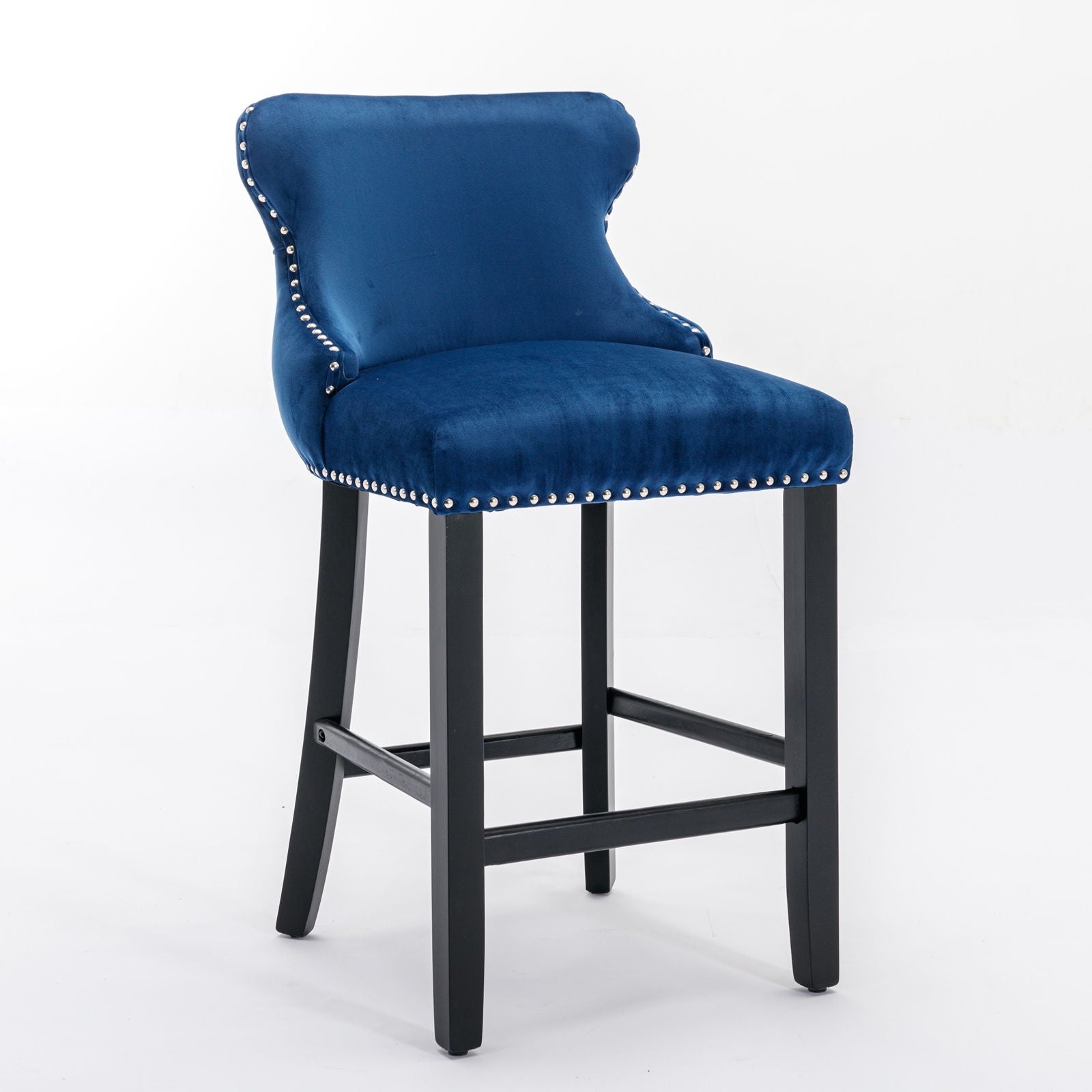 A set of 2 contemporary blue velvet wing-back bar stools with button tufted decoration, wooden legs, and chrome nailhead trim, shown on a white background.
