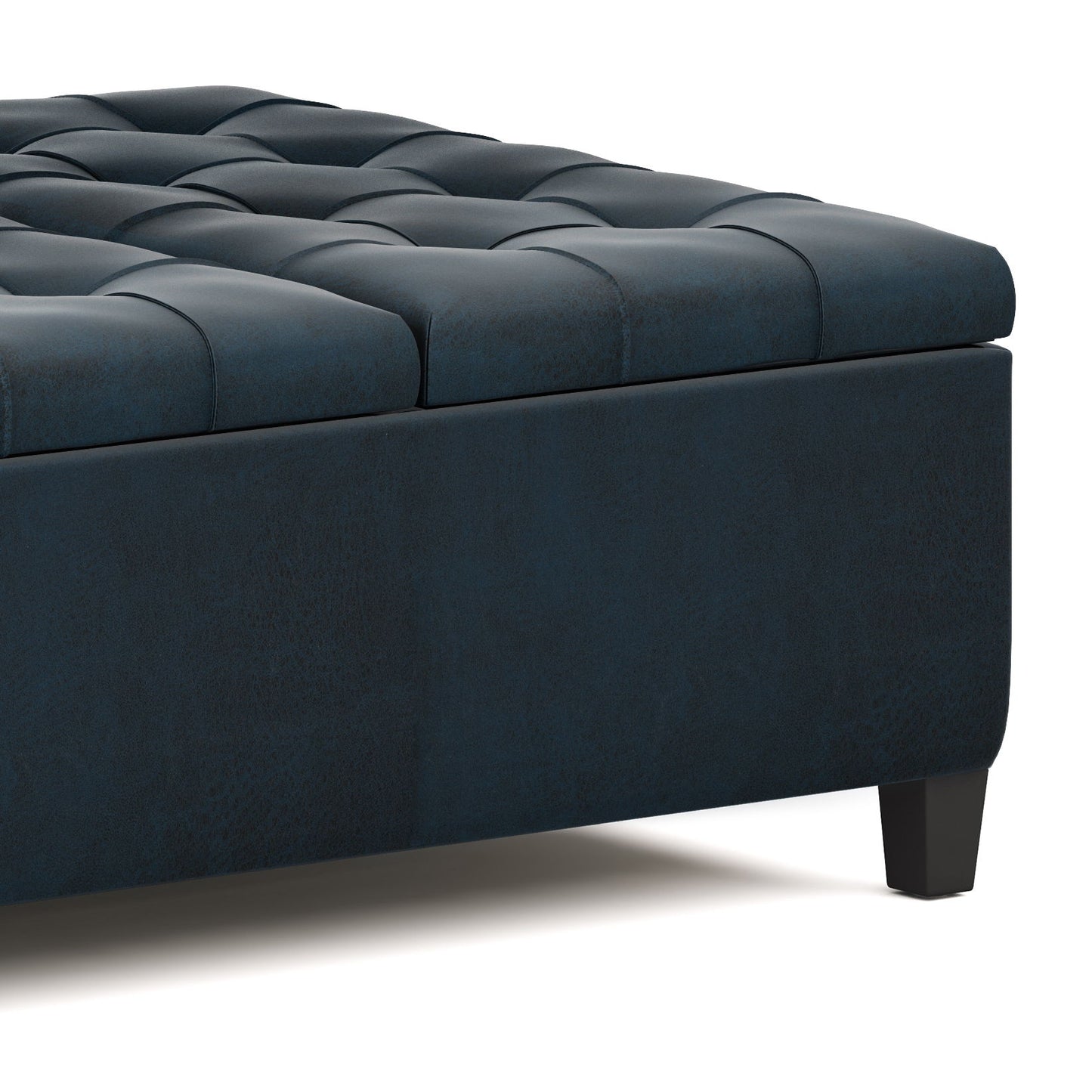 Close-up of the Harrison - Large Coffee Table Storage Ottoman, showcasing its dark blue tufted upholstery, cushioned top, smooth fabric texture, and short black legs.