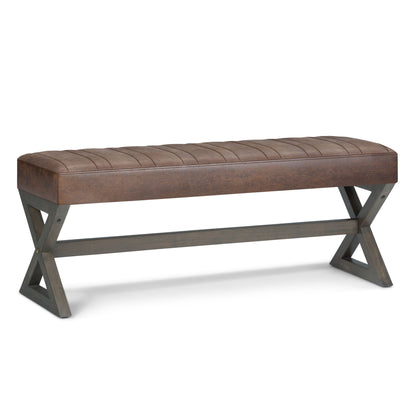 The Salinger - Large Upholstered Ottoman Bench features a brown tufted cushioned seat and wooden legs in an X-shaped design, connected by a horizontal support bar.