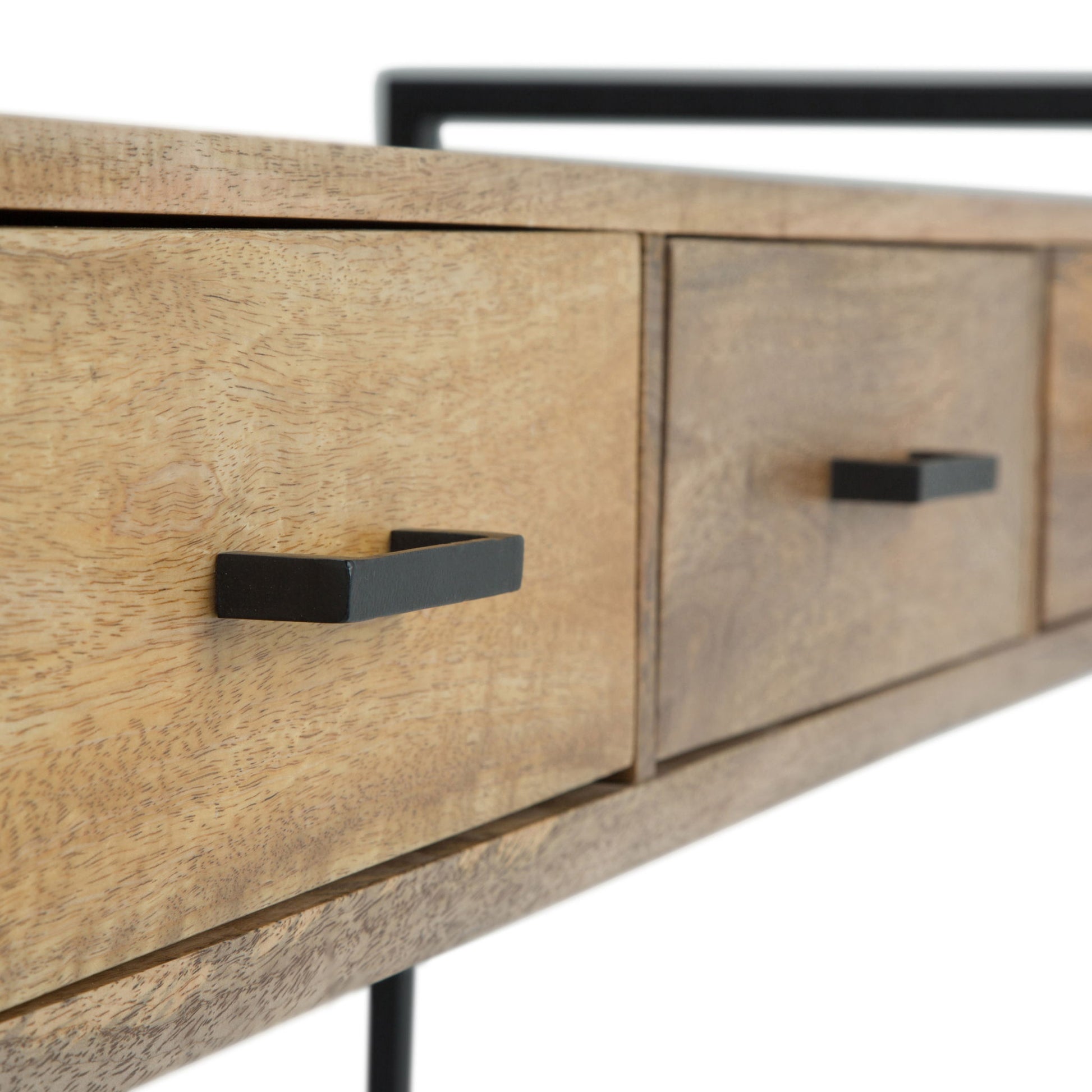 Close-up of the Riverside - Table, featuring a minimalistic design with black metal handles, highlighting the wood texture and part of its metal frame.