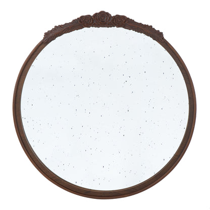 The Round Hand Carved Rose Antique Mirror Frame is a wall mirror for living spaces, featuring a dark wooden frame with carved roses at the top and slightly speckled vintage-style glass.
