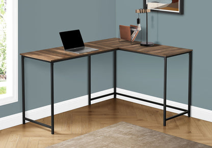 The Computer Desk Home Office, Corner, L Shape, Contemporary & Modern features a wood surface and black metal frame on a herringbone floor. On the desk are a laptop, lamp, and books. The room has blue-gray walls and a beige rug.