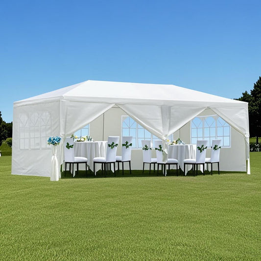 A 10X20' Outdoor Garden Gazebo Wedding Party Tent Canopy with removable sidewalls stands on grass, containing tables with white cloths and chairs adorned with white and blue flowers under a clear blue sky.