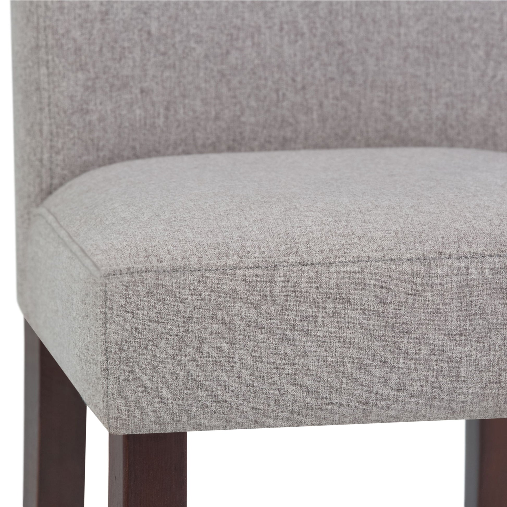 Close-up of the Acadian - Upholstered Parson Dining Chair seat, featuring light gray fabric, dark wooden legs, and a straight, partially visible back. Set of 2.