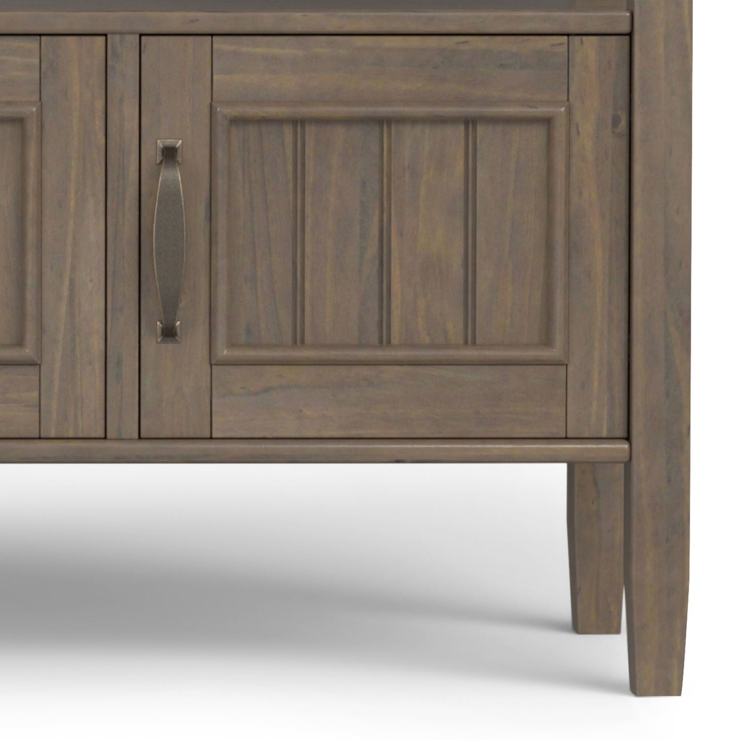 Close-up of the lower section of the Lev Console Table in smoky brown finish, featuring panel detailing, a handle on one door, and tapered legs, set against a plain white background.