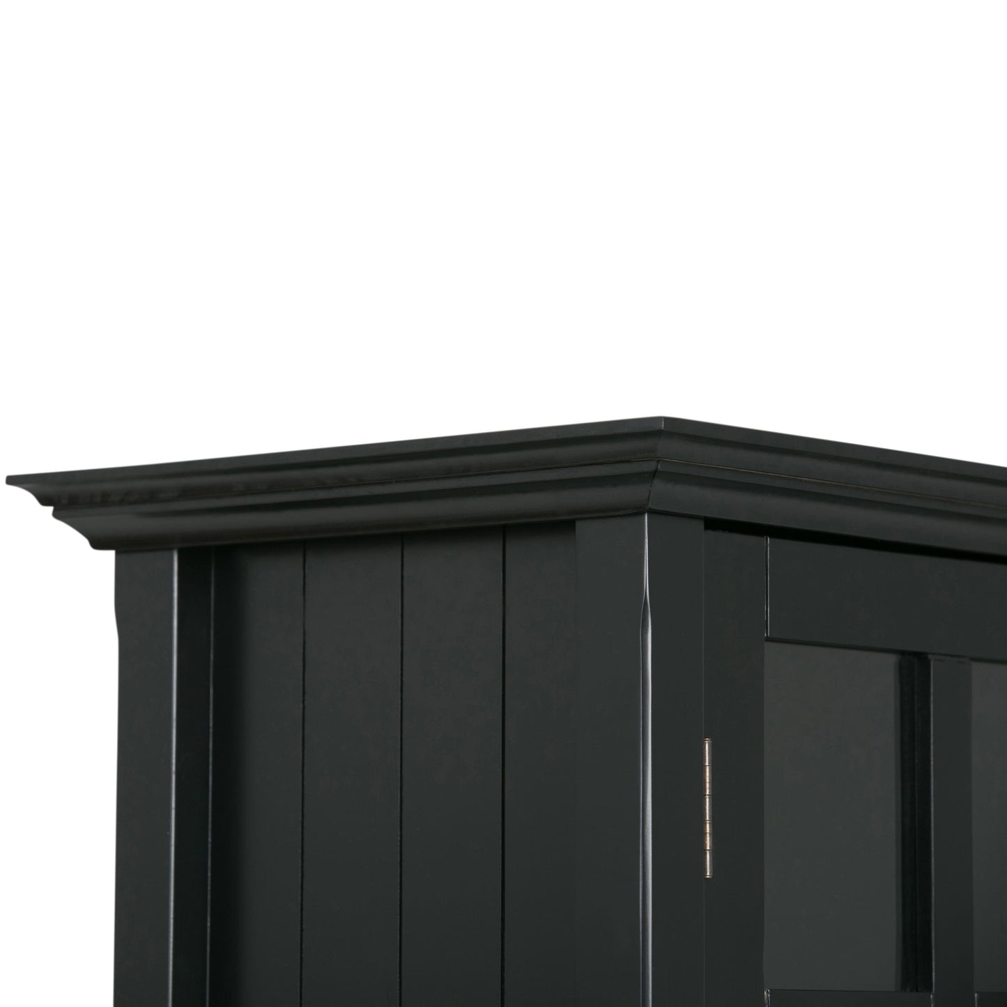 Close-up of the top corner of the Acadian - Medium Storage Cabinet, Handcrafted, featuring black wood with vertical panels and decorative crown molding along the upper edge.