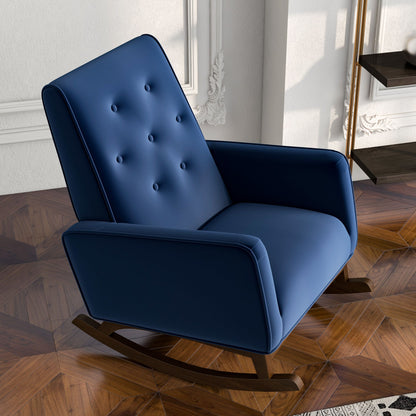 The Demetrius Solid Wood Rocking Chair, featuring modern blue upholstery and a button-tufted backrest, stands on a patterned wooden floor in a stylish room with white paneled walls and decorative molding.