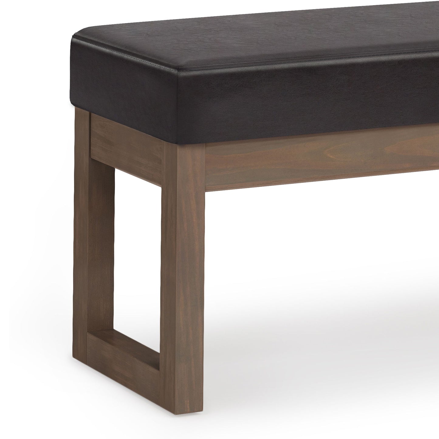 A close-up of the Milltown - Upholstered Ottoman Bench features a dark cushioned seat and wooden legs, displayed against a white background.