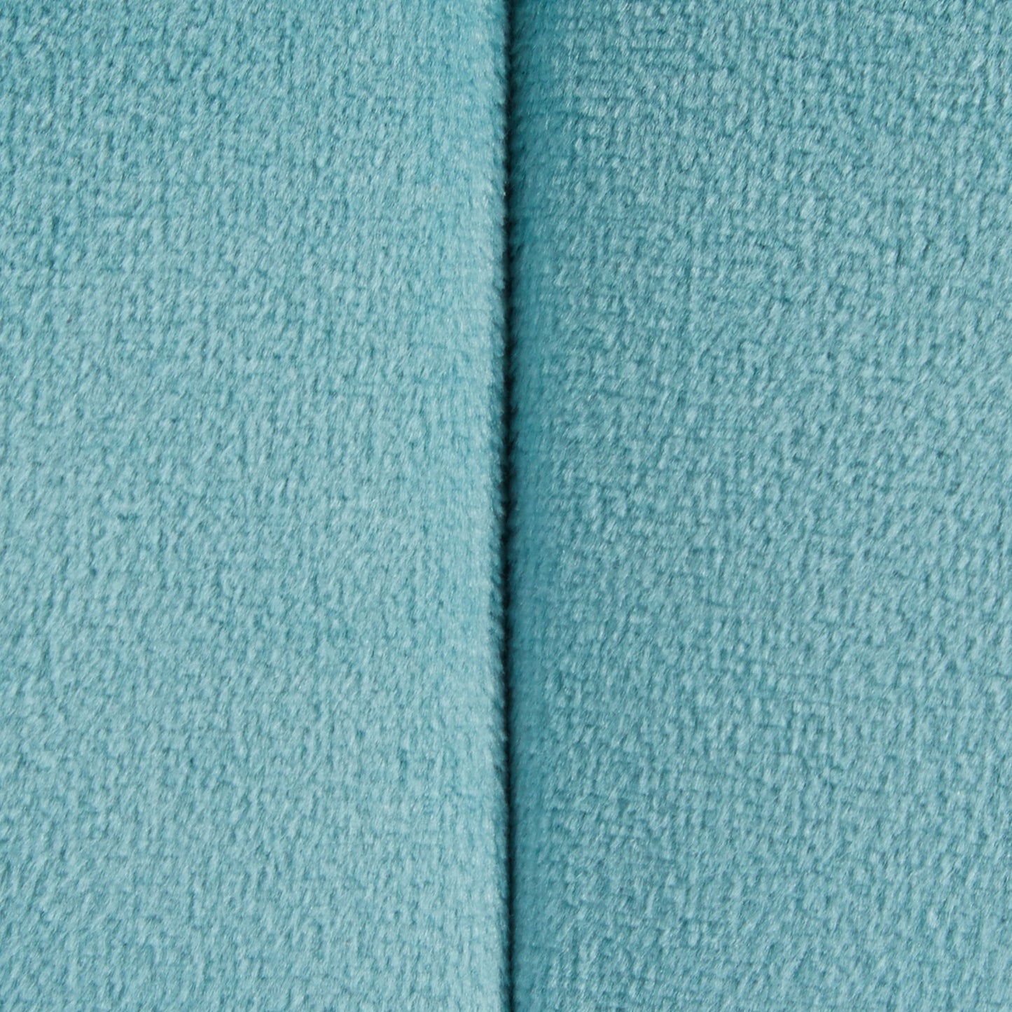 Close-up of the Braided - Versatile Round Ottoman in light blue, showing its soft fleece fabric and a central vertical seam dividing the ottoman into two textured sections.