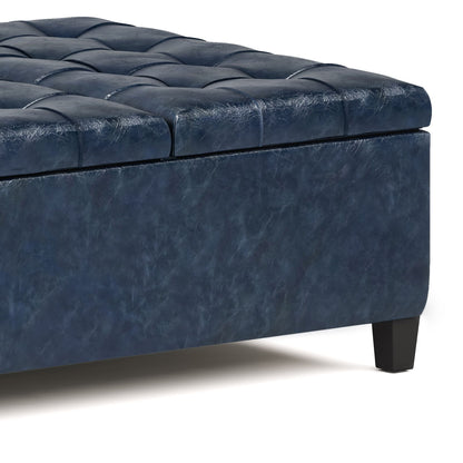 Close-up of the Harrison Upholstered Coffee Table Storage Ottoman in blue tufted faux leather with black wooden legs, shown on a white background.