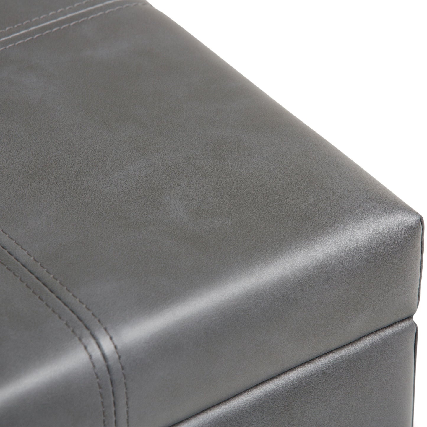 Close-up of the Dover Upholstered Storage Ottoman Bench in gray leather, showcasing visible stitching and a smooth, matte surface.
